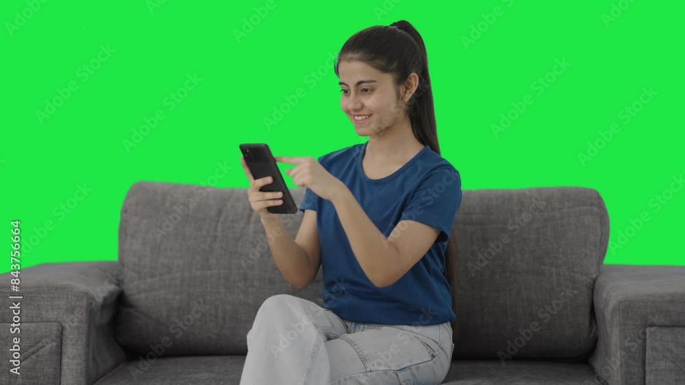 Happy Indian teenage girl scrolling phone Green screen Happy Indian teenage girl scrolling phone Green screen