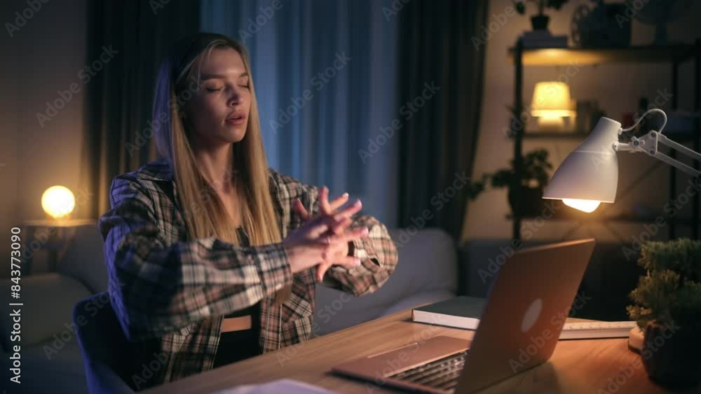 A young woman working late on her laptop in a cozy home setting with warm lighting and a relaxing atmosphere A young woman working late on her laptop in a cozy home setting with warm lighting and a relaxing atmosphere