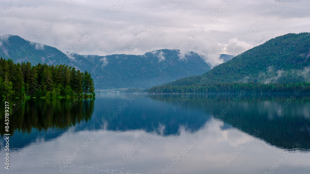 Araksfjorden Lake in Norway, a beautiful mountain lake at sunrise with reflections in the water Araksfjorden Lake in Norway, a beautiful mountain lake at sunrise with reflections in the water