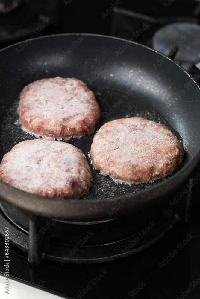 Meatballs or small meat patties cutlets sizzling in oil while frying in a pan on the stove. Concept of home cooking, traditional recipes, and culinary preparation Meatballs or small meat patties cutlets sizzling in oil while frying in a pan on the stove. Concept of home cooking, traditional recipes, and culinary preparation