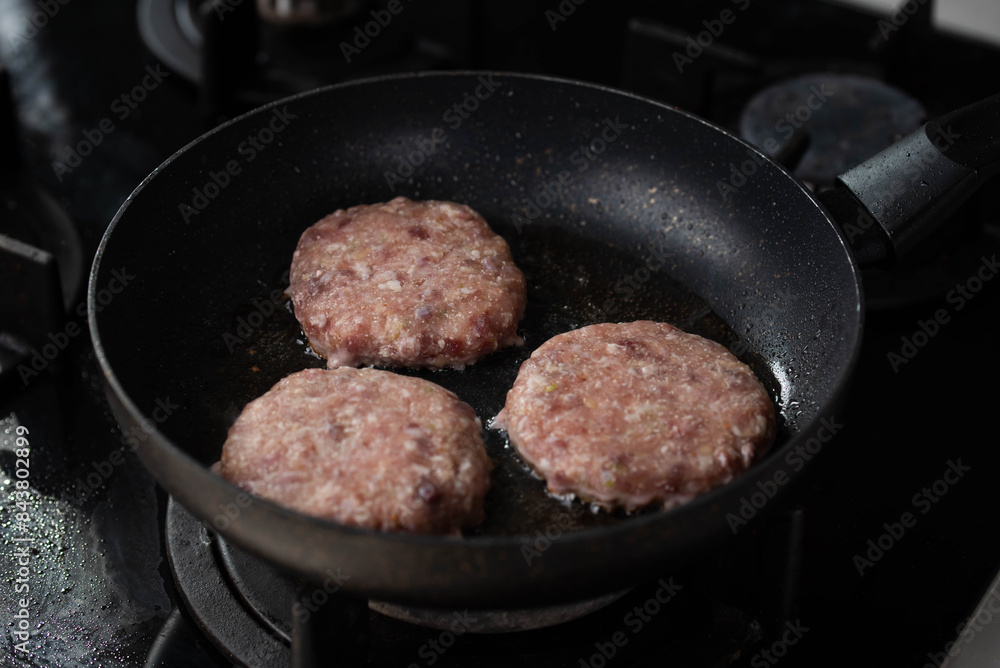 Meatballs or small meat patties cutlets sizzling in oil while frying in a pan on the stove. Concept of home cooking, traditional recipes, and culinary preparation Meatballs or small meat patties cutlets sizzling in oil while frying in a pan on the stove. Concept of home cooking, traditional recipes, and culinary preparation
