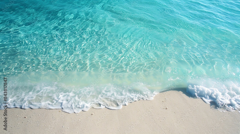 A gentle wave laps at the pristine white sand beach, the turquoise water sparkling in the sun. A gentle wave laps at the pristine white sand beach, the turquoise water sparkling in the sun.