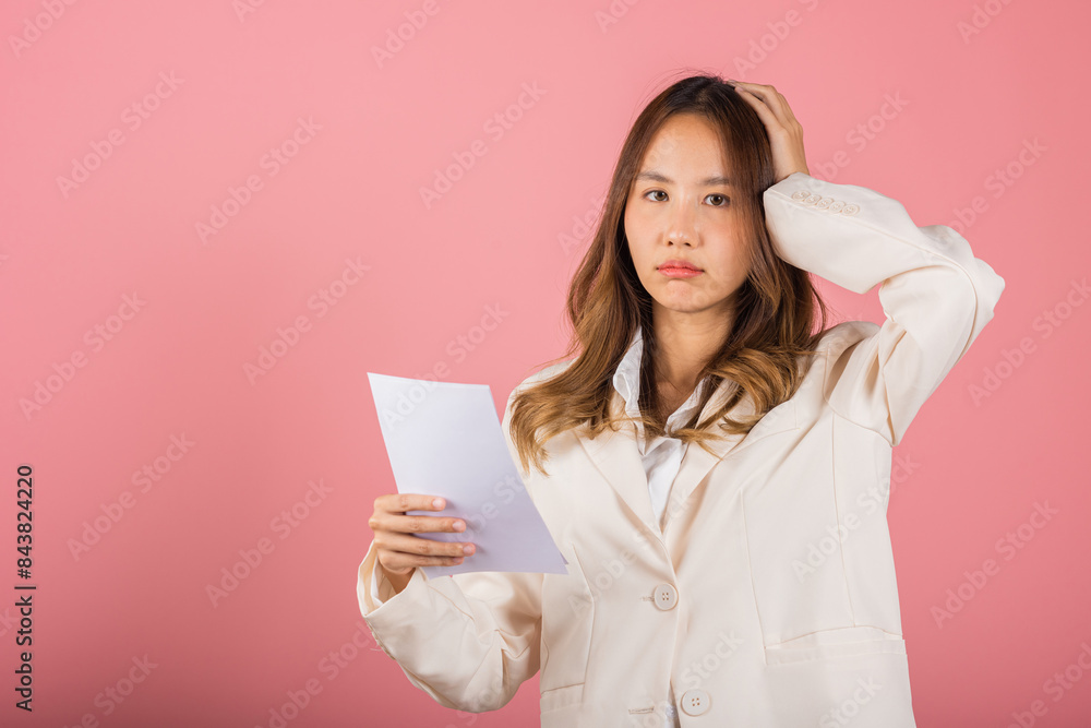 Portrait of beautiful Asian young woman sad tired strain holding paper calculating bills on hand, female person problem she hold worried over bill, studio shot isolated on pink background Portrait of beautiful Asian young woman sad tired strain holding paper calculating bills on hand, female person problem she hold worried over bill, studio shot isolated on pink background