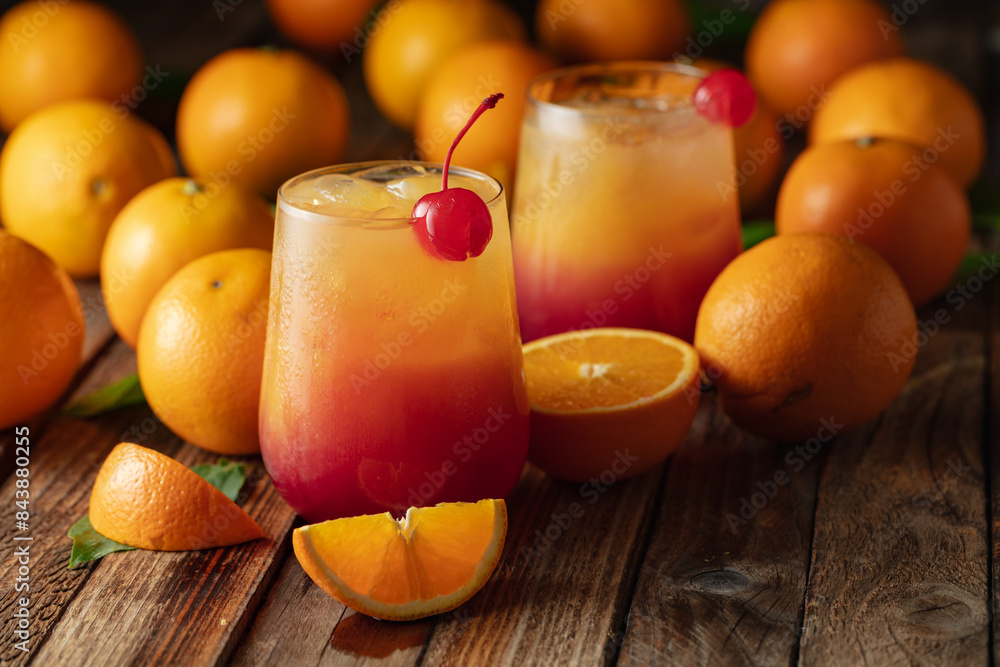 Classic tequila sunrise cocktail on an old wooden table. Classic tequila sunrise cocktail on an old wooden table.