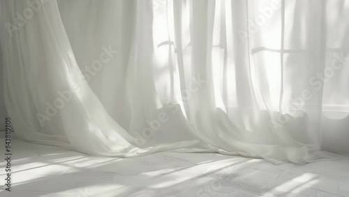 White curtain is hanging in front of window, letting in sunlight
