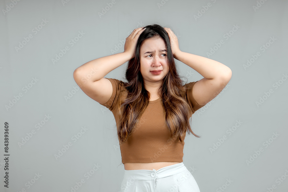 Portrait of a happy Asian Indonesian woman holding her head with both hands, isolated on a white background Portrait of a happy Asian Indonesian woman holding her head with both hands, isolated on a white background