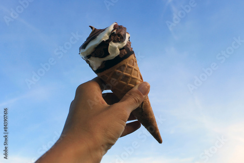 ice cream against the sky. hand holding ice cream