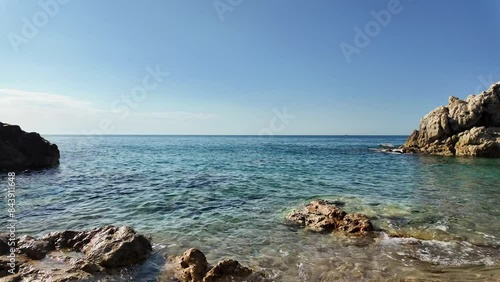 Beautiful sea view on an empty rocky beach with blue sky in Spain, background, 4K photo