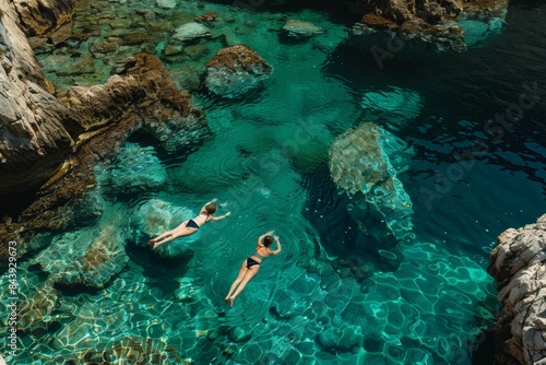 Two Women Swimming in Crystal Clear Waters