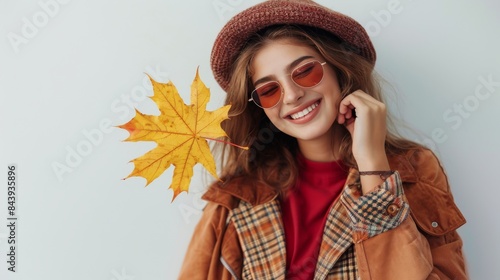 Woman Holding Yellow Autumn Leaf in Front of Face, Wearing Plaid Shirt and Hat