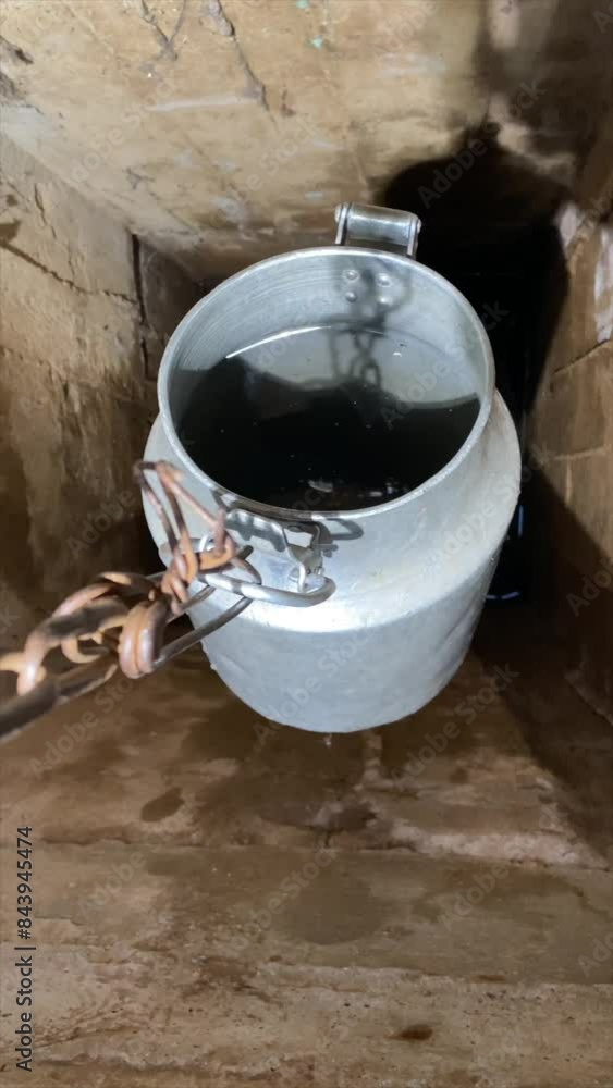 vertical video Bucket on a chain for extracting water from a well. vertical video Bucket on a chain for extracting water from a well.