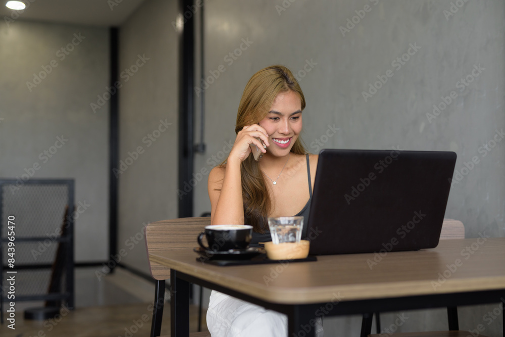 Beautiful woman sitting in cafe wearing professional clothing while using laptop computer Beautiful woman sitting in cafe wearing professional clothing while using laptop computer