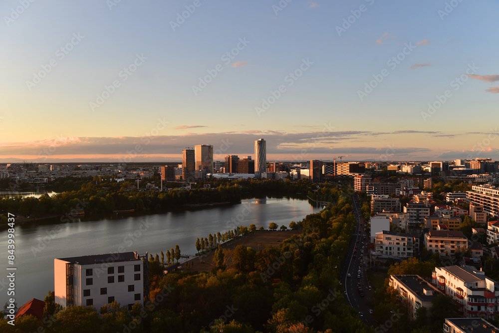 The light of the sunset illuminates the tall buildings of north part of Bucharest in the new area with tall office buildings and Herastrau lake.. The light of the sunset illuminates the tall buildings of north part of Bucharest in the new area with tall office buildings and Herastrau lake..