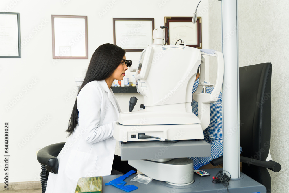 Skilled ophthalmologist uses cutting-edge equipment to assess a patient's vision at a state-of-the-art eye care center Skilled ophthalmologist uses cutting-edge equipment to assess a patient's vision at a state-of-the-art eye care center
