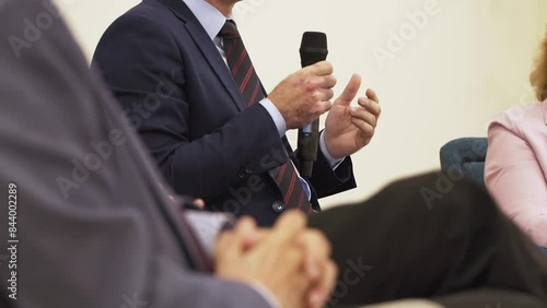 Businessman speaks at conference hall. Man holds a microphone and speaks at a business forum
