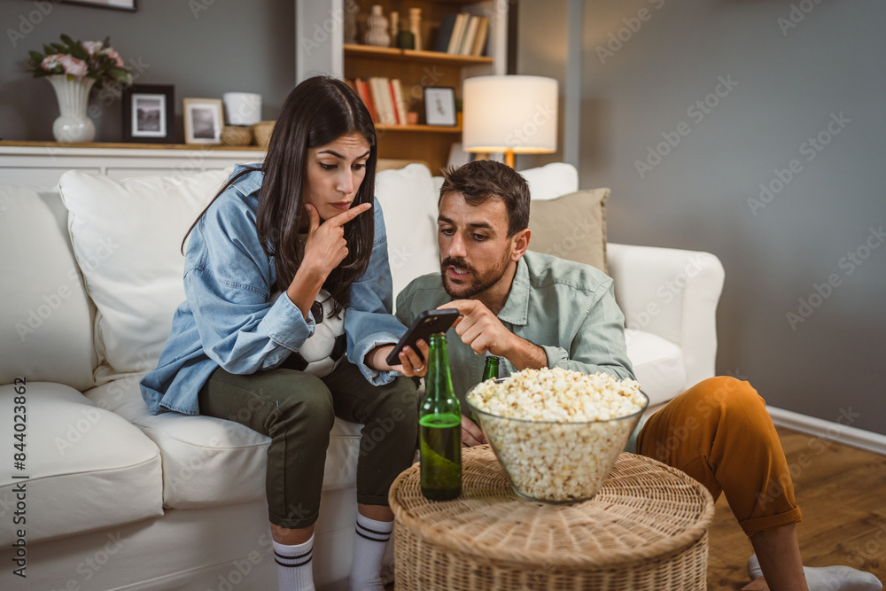 couple watch football match together on mobile phone at home couple watch football match together on mobile phone at home