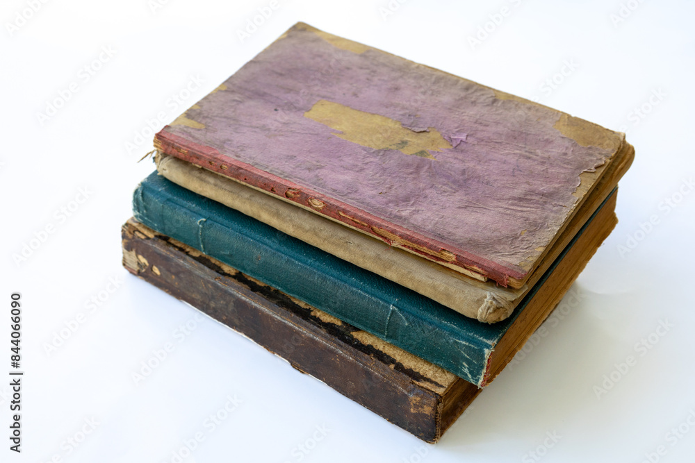 Old damaged books stacked on top of each other. Yellowed natural paper texture. On isolated white background. Clean close-up. Old damaged books stacked on top of each other. Yellowed natural paper texture. On isolated white background. Clean close-up.