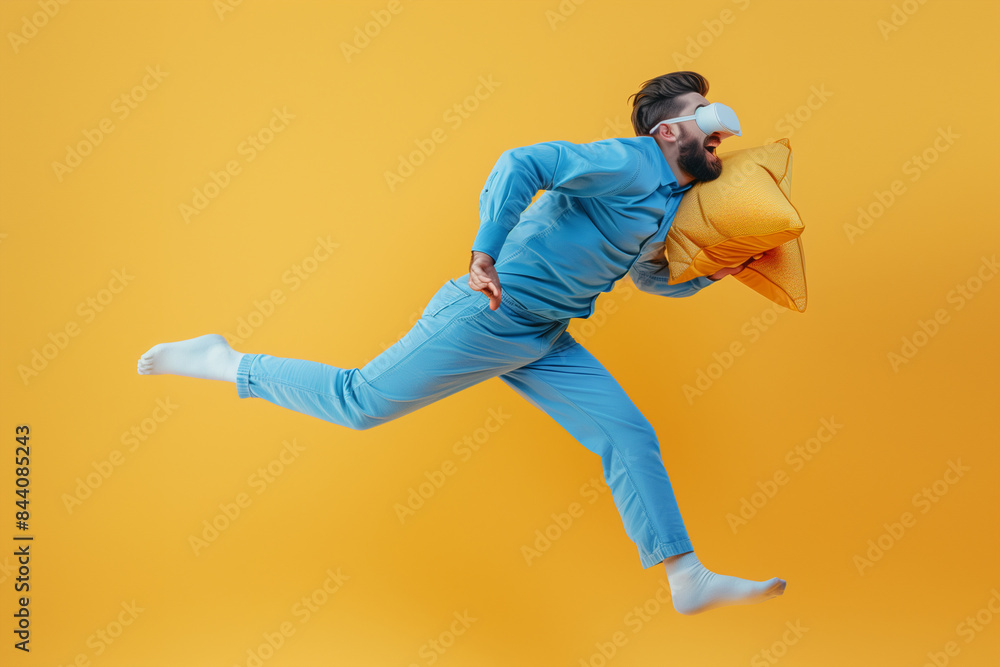 Man in Blue Pajamas Jumps While Holding a Pillow on a Yellow Background Man in Blue Pajamas Jumps While Holding a Pillow on a Yellow Background