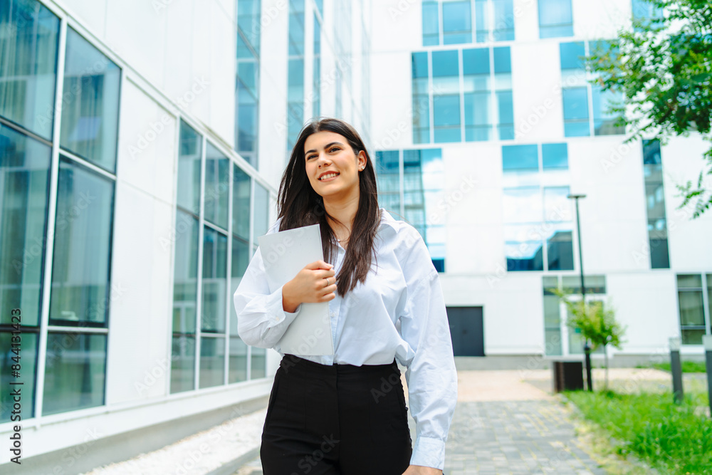 One young successful business woman going to work at business office modern building while holding coffee and papers One young successful business woman going to work at business office modern building while holding coffee and papers
