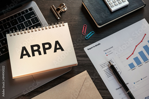 There is notebook with the word ARPA. It is an abbreviation for Average Revenue per Account as eye-catching image. photo