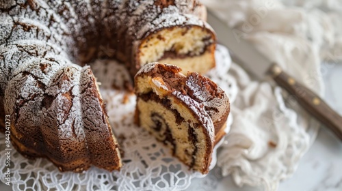 Marble bundt cake sliced on a white lace with a kitchen knife photo