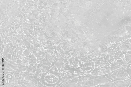White water with ripples on the surface. Defocus blurred transparent white colored clear calm water surface texture with splashes and bubbles. Water waves with shining pattern texture background.
