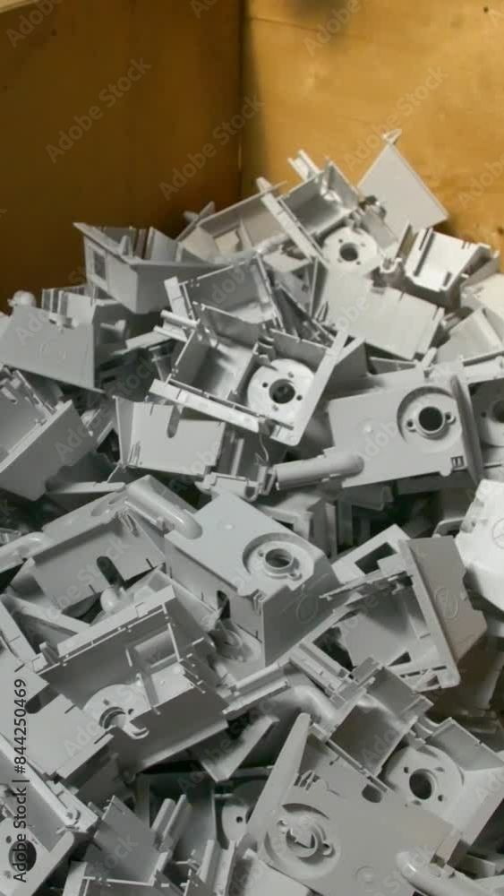 Plastic parts shop in a factory. Manufacturing of plastic parts and fittings for electric heaters in the factory. The machine stamps plastic parts. Vertical video. Plastic parts shop in a factory. Manufacturing of plastic parts and fittings for electric heaters in the factory. The machine stamps plastic parts. Vertical video.