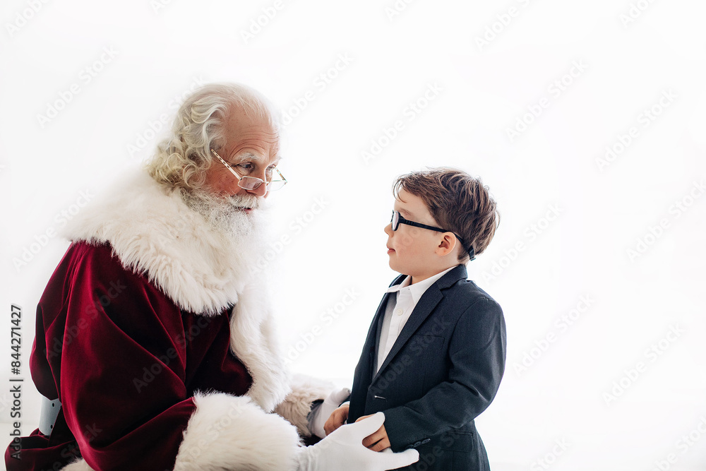 Obraz premium Santa talking to boy in suit with white background, close-up