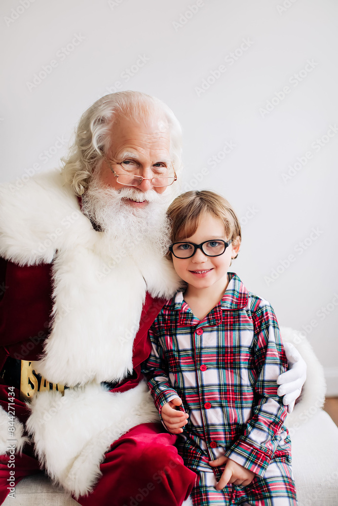 Santa with a boy in plaid pajamas, minimalistic indoor setting, Santa with a boy in plaid pajamas, minimalistic indoor setting,