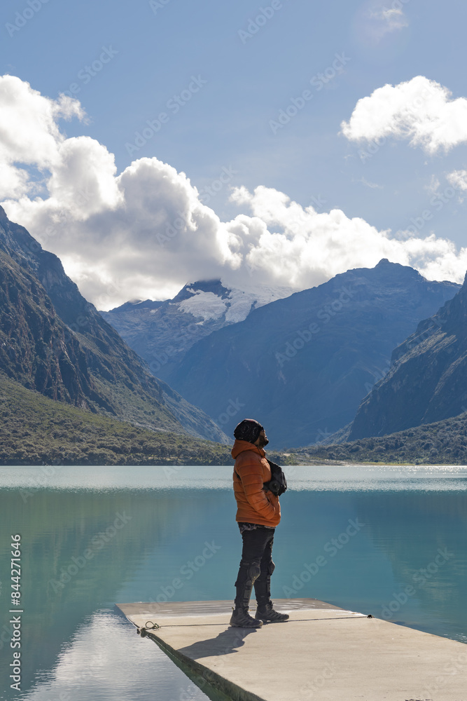 Man standing on a jetty on lake looking snowy mountain Man standing on a jetty on lake looking snowy mountain