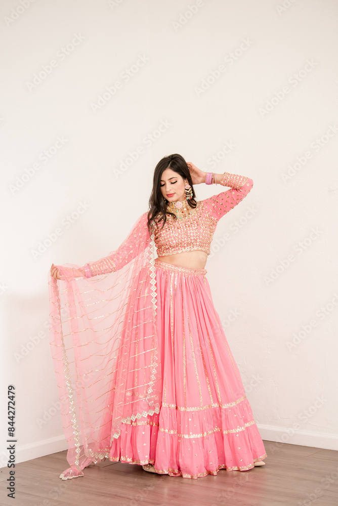 Women standing and holding shawl from her pink saree Women standing and holding shawl from her pink saree
