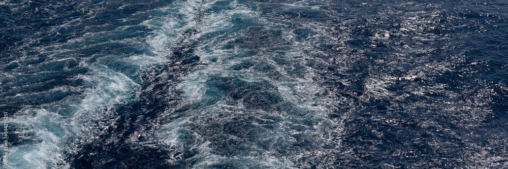 Panorama of waves and turbulence from the wake of a boat in the sea as a background texture Panorama of waves and turbulence from the wake of a boat in the sea as a background texture