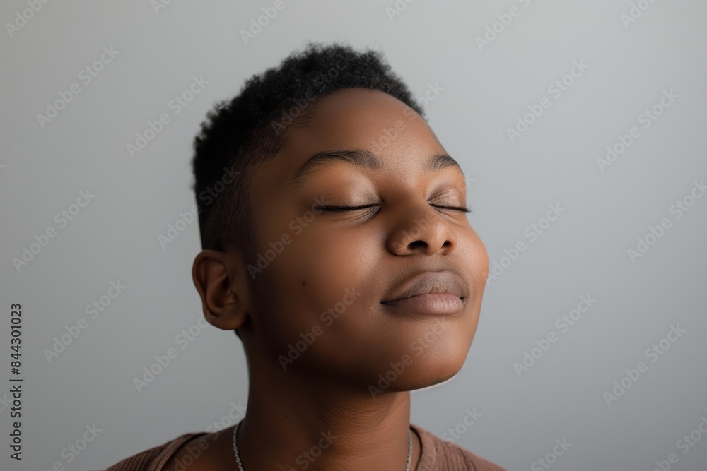 A woman with a shaved head with a peaceful expression on her face A woman with a shaved head with a peaceful expression on her face