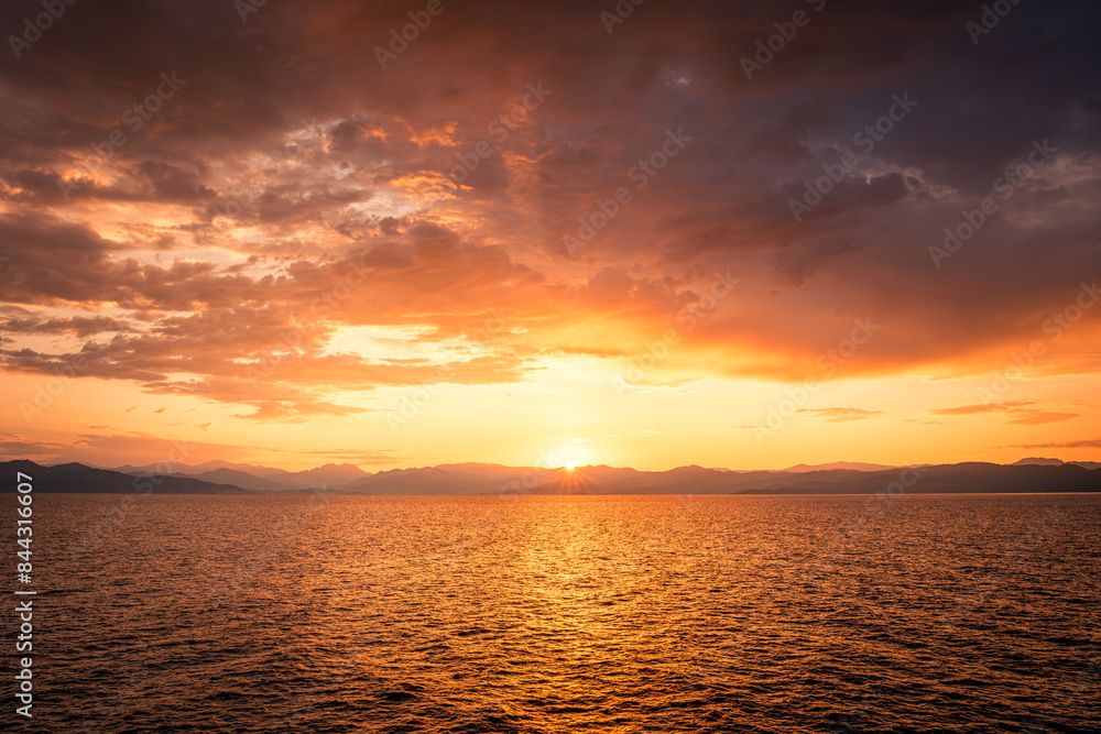 Beautiful golden sunrise over the rugged coastline of the island of Corsica as the sun lights up the Mediterranean sea