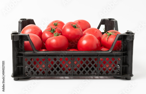Ripe tomatoes in a black plastic box