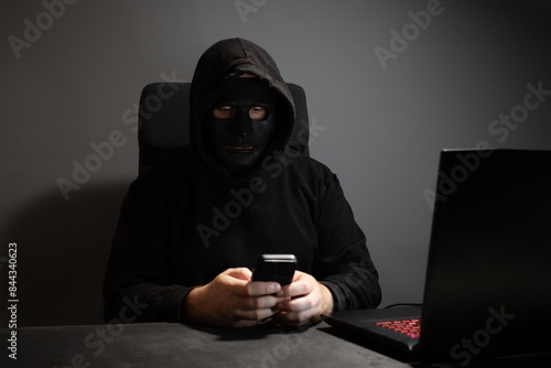 Schilderij op canvas Man in a mask with a phone, anonymous, spy, stalker.