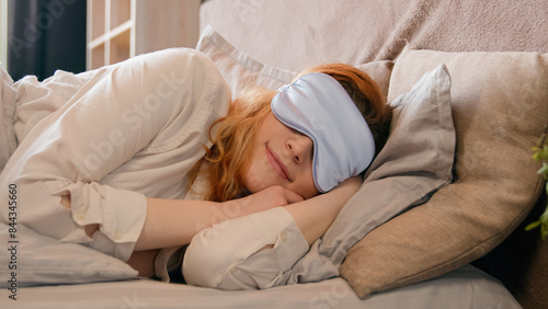 Принти на полотні Sleepy beautiful woman waking up lying in comfortable white bed peeks out from u