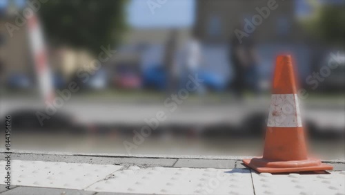 Traffic cone on pavement with blurred traffic in the background photo