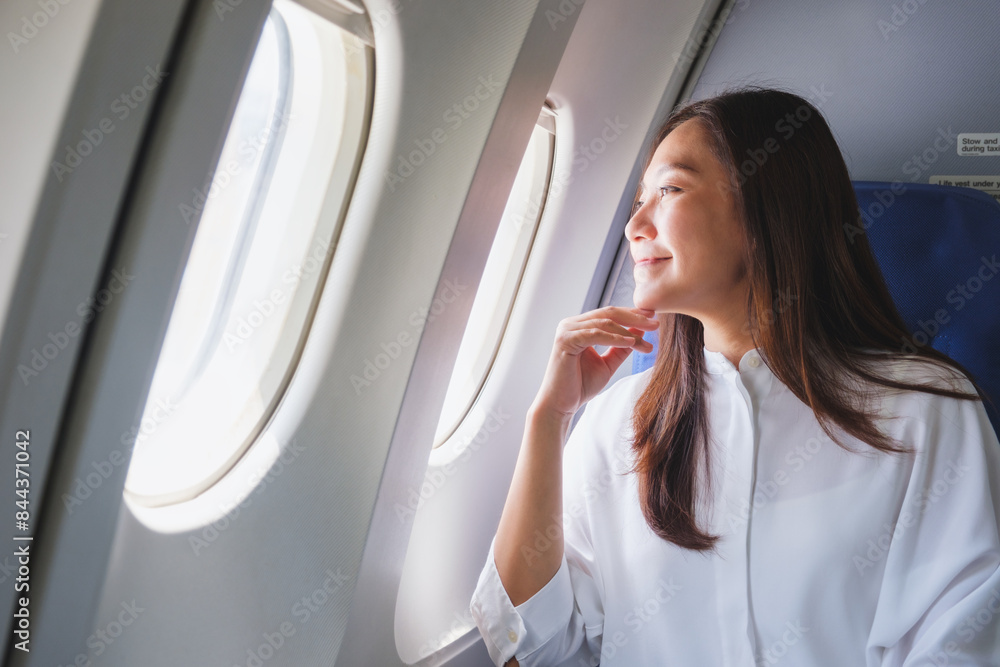 © Farknot Architect - Portrait image of a woman looking through an airplane window