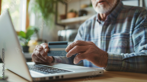 Elderly Bearded Man Enjoying Black Friday Online Shopping | Joyful Senior Male Using Laptop and Credit Card for E-Commerce Purchases at Home