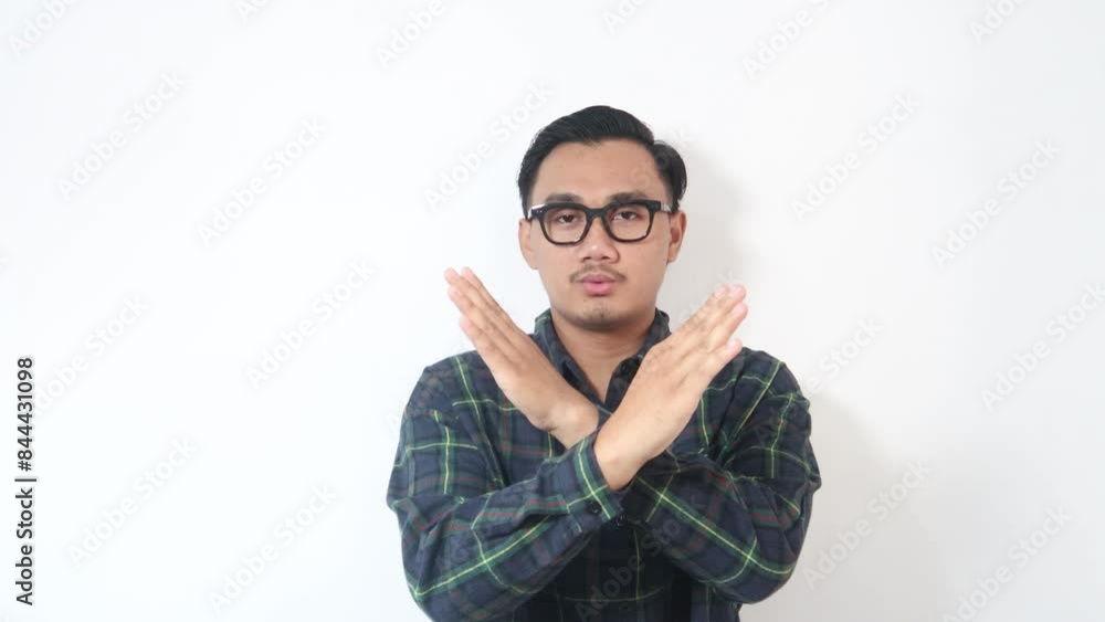 A man from Asia wearing a green shirt, looking surprised, and then gesturing to stop someone from continuing an action. Isolated on a white background. A man from Asia wearing a green shirt, looking surprised, and then gesturing to stop someone from continuing an action. Isolated on a white background.