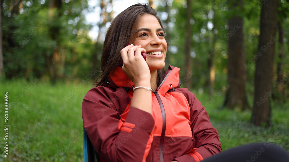 Beautiful, young woman taking a break during hiking and talking on mobile phone Beautiful, young woman taking a break during hiking and talking on mobile phone