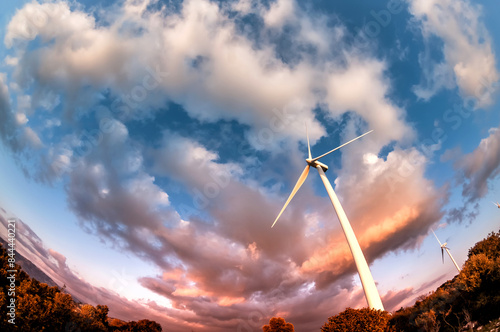 Obraz na płótnie Wind turbine against a dramatic, cloudy, evening sky