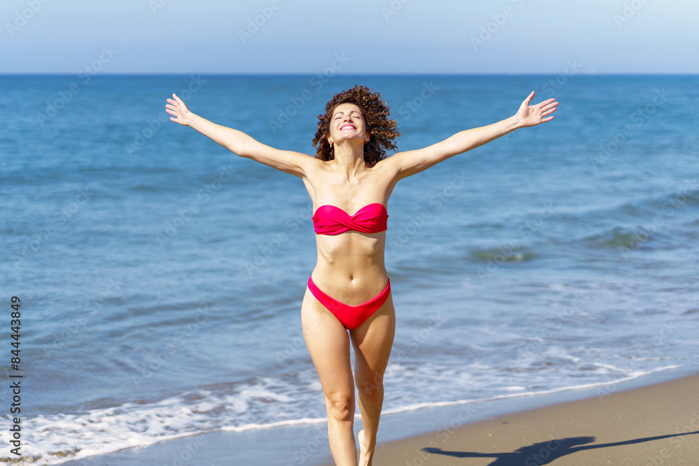 Slim woman in bikini walking near sea Slim woman in bikini walking near sea
