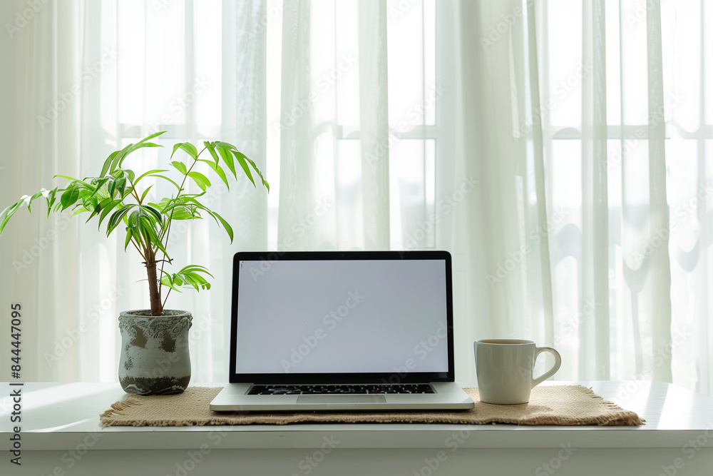 A minimalistic home office setup showcasing a laptop, coffee cup, and a potted plant on the table. The scene features a pristine white background, with window light gently illumina A minimalistic home office setup showcasing a laptop, coffee cup, and a potted plant on the table. The scene features a pristine white background, with window light gently illumina