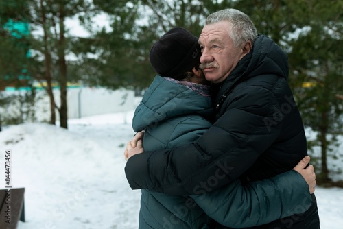 Cute retired couple walking in the park and hugging each other in winter park © Ivan Traimak