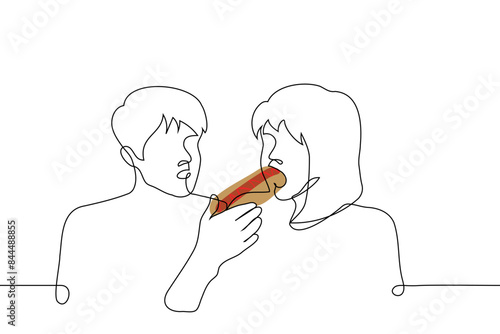 woman eats a hotdog, the other watches him - one line art vector. gourmet concept, hungry satisfies hunger with fast food, envy someone else's metabolism