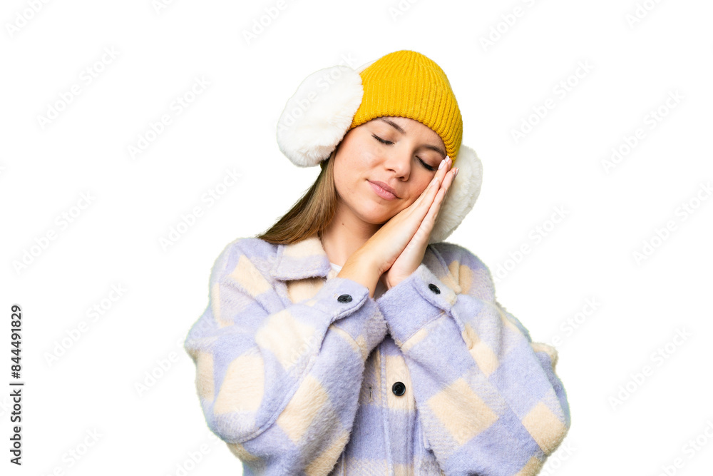 Young blonde woman wearing winter muffs over isolated chroma key background making sleep gesture in dorable expression Young blonde woman wearing winter muffs over isolated chroma key background making sleep gesture in dorable expression