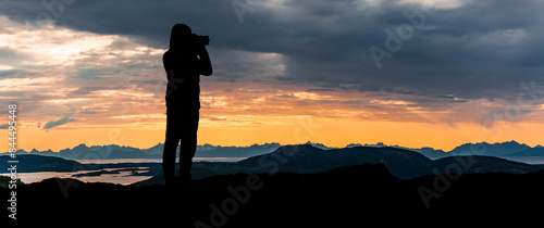 Fotograf im Gegenlicht als Silhouette beim Fotografieren von einem Landschaft...