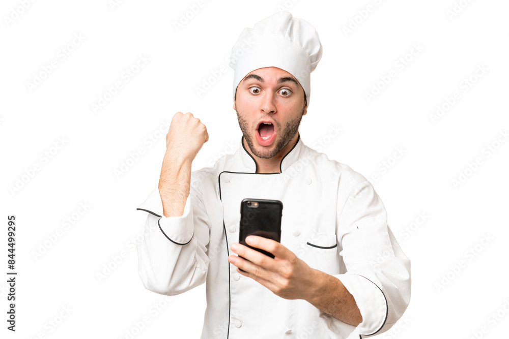 Young handsome chef man over isolated background surprised and sending a message